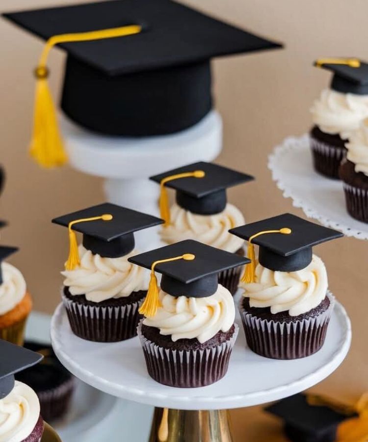 Chocolate cupcakes with vanilla icing topped with black grad caps