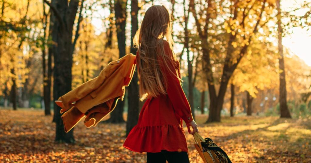 Woman in a forrest swinging her coat and purse. Photo credit: Iryna Imago @gettyimages