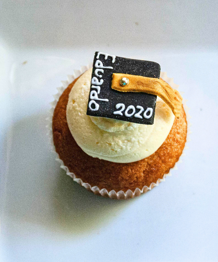 Carrot cake cupcake with grad's name written on the grad cap cupcake topper