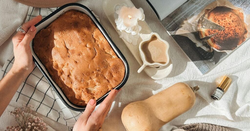Cozy fall flat lay with squash bread, squash, coffee and and open cookbook
