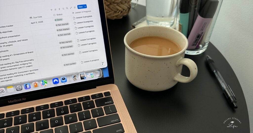 An open student laptop showing a Notion study planner on a table beside a cup of coffee and jar of pens.