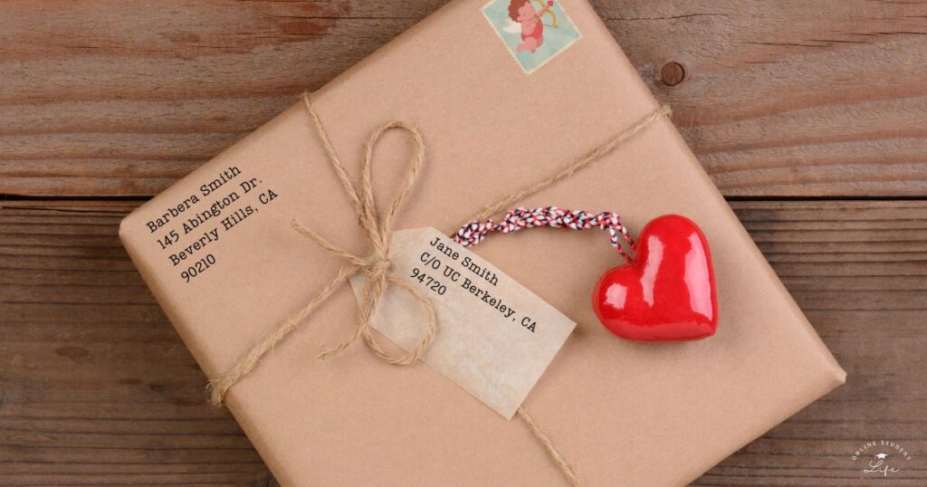 An addressed brown paper package tied with string with a heart-shaped decoration attached to the tag.