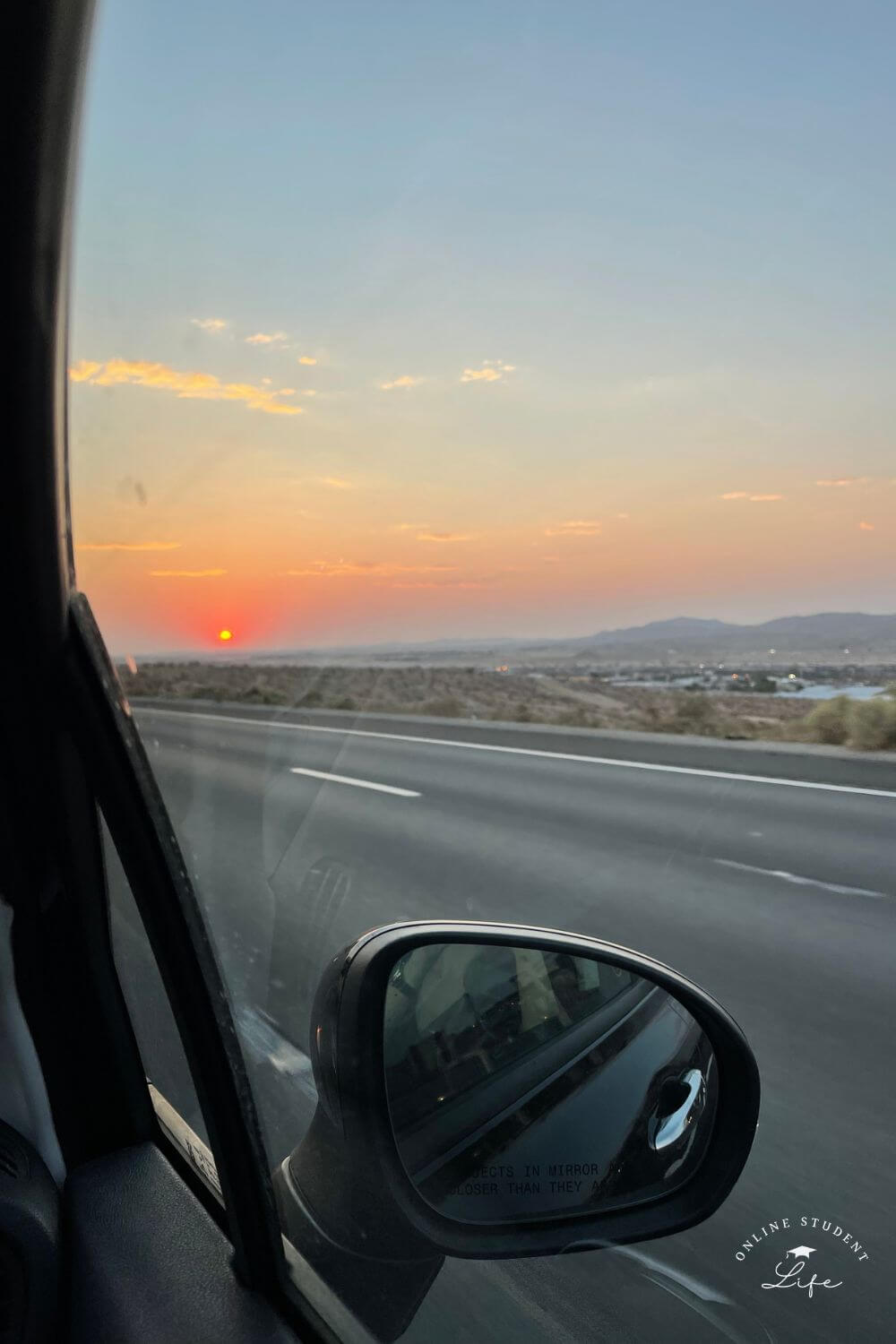 View of a desert sunset out of a car passenger window.