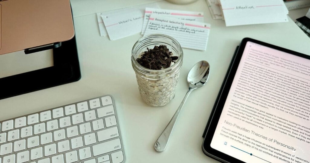 A jar of chocolate chip overnight oats on a study desk.
